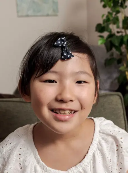 AES英会話に通う9歳のMarikaちゃんの笑顔の写真。ネイティブの発音や単語を自然に理解する力に驚いたと語るお母さん。